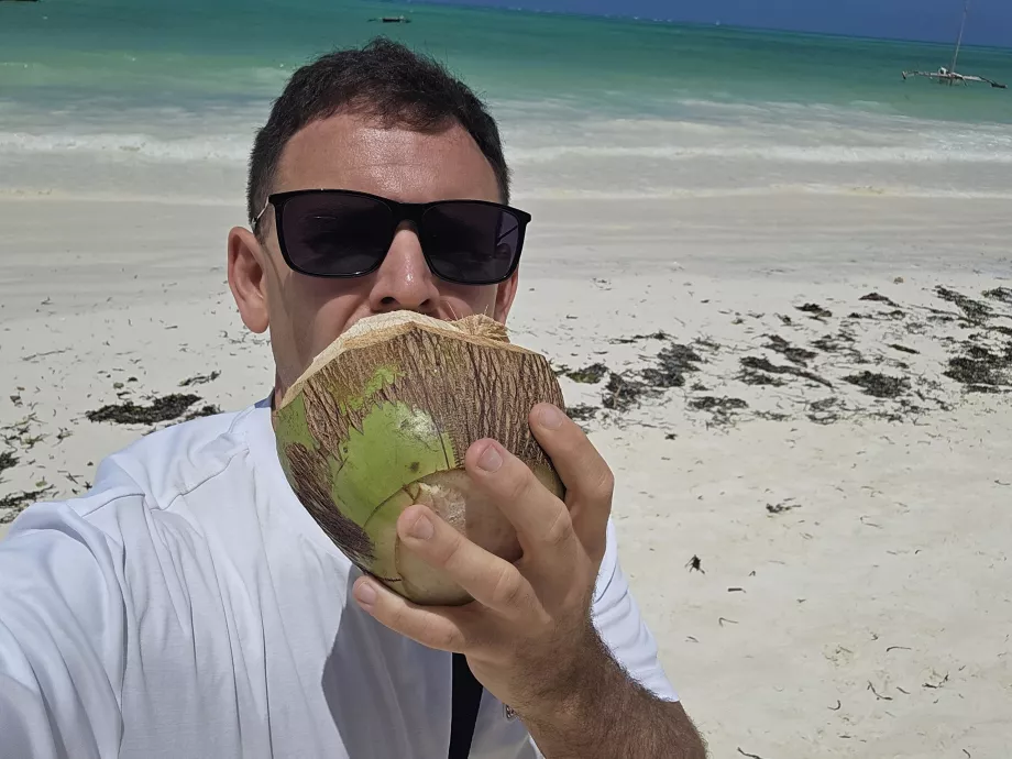 Jeg drikker kokosnød på stranden i Paje